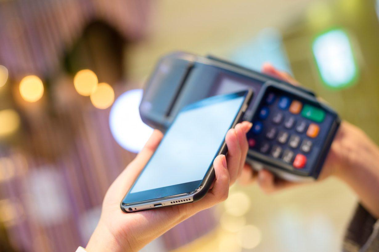 Woman pay with cellphone by NFC technology NFC and MIFARE®DESFire® family